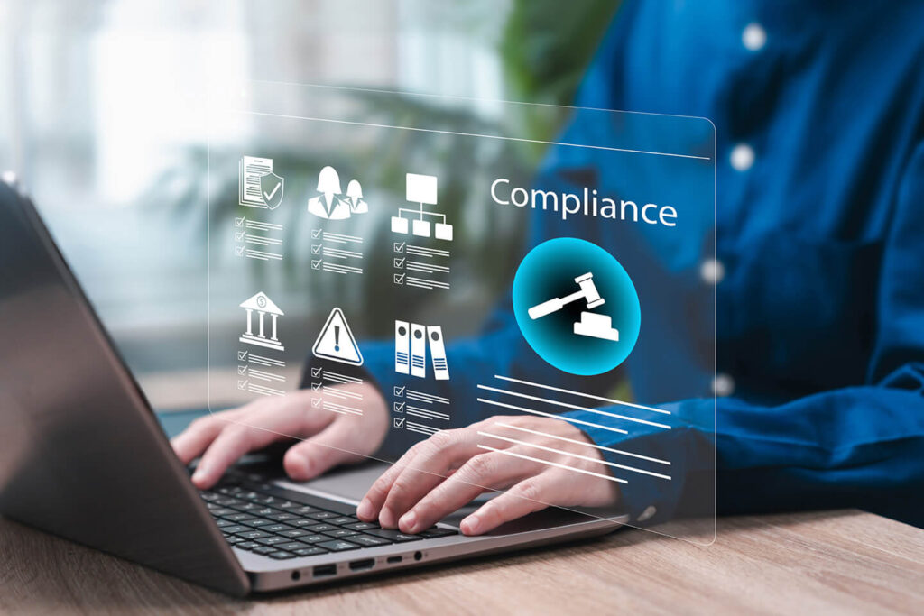 Profissional de camisa manga longa azul digitando em um notebook e ícones digitais indicando conformidade da gestão fiscal.
